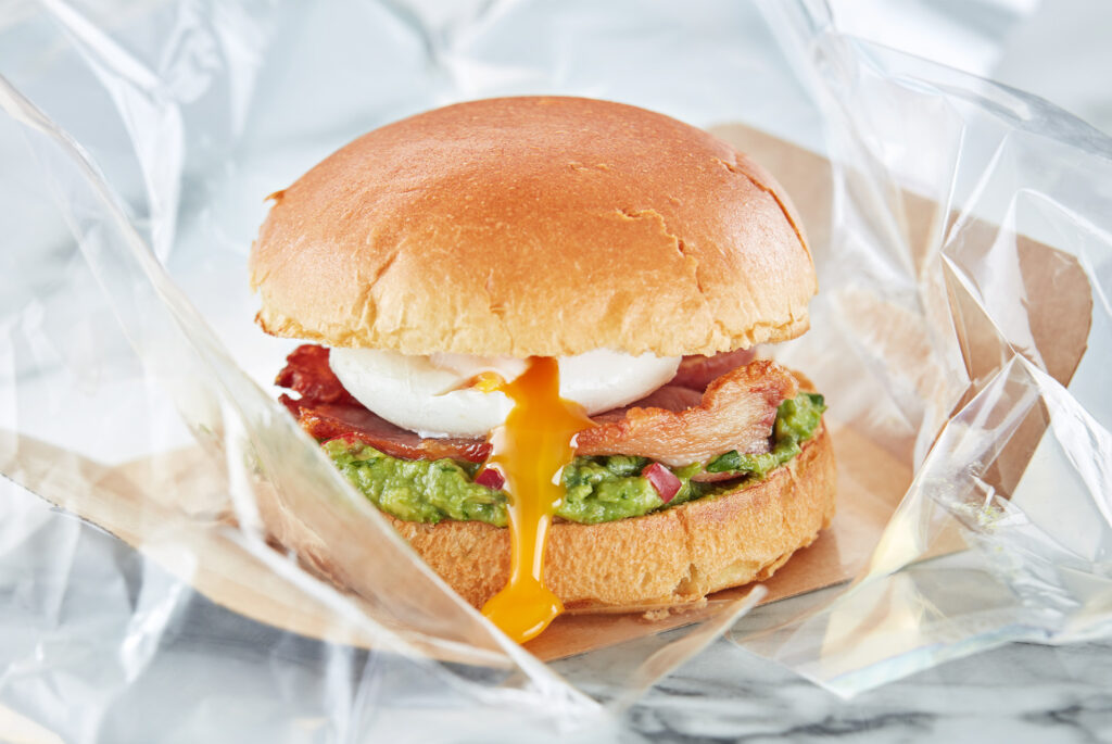 Breakfast sandwich with poached egg, bacon and avocado which has been taken from a Flexeserve hot-holding unit